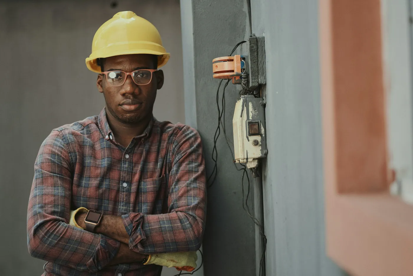 Responsável técnico habilitado em canteiro de obra Engenheiro com capacete e óculos de proteção em canteiro de obra, próximo a um quadro elétrico