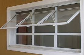 Janela Maxim-ar Branca a Pronta Entrega na Baixada Fluminense | Orçamento Janela de alumínio branco com três folhas superiores do tipo projetante (maxim-ar) abertas, instalada em uma parede na cor ocre.