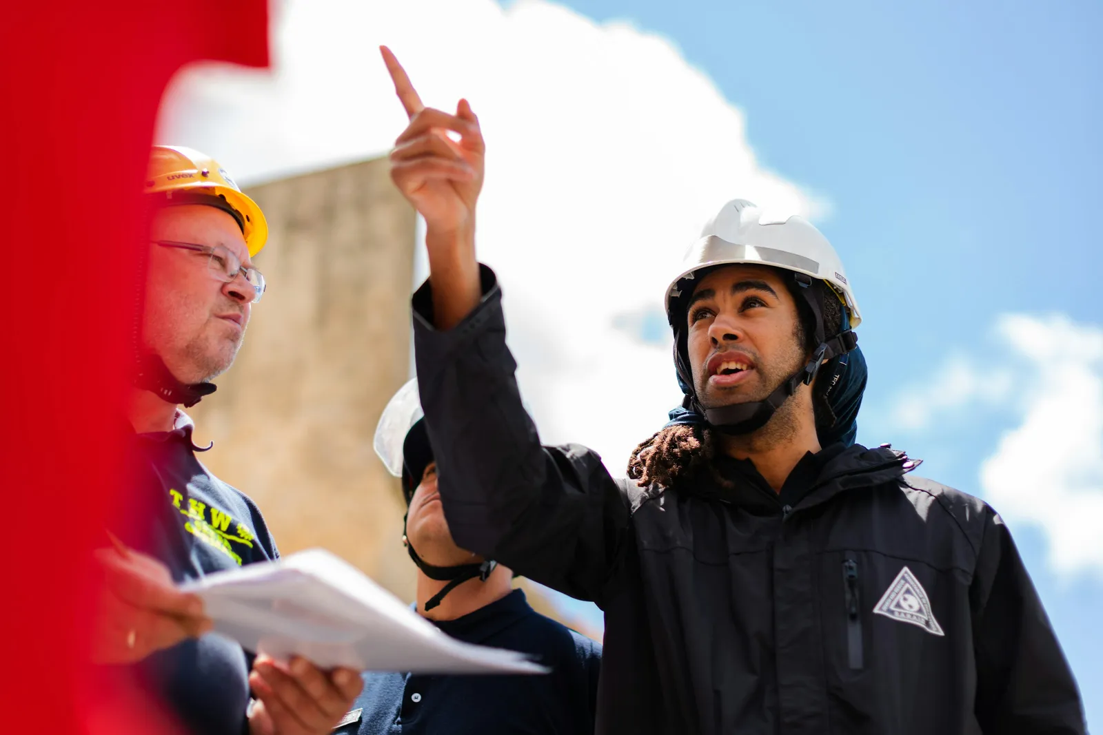 Engenheiro liderando equipe técnica de manutenção predial em vistoria de edifício
