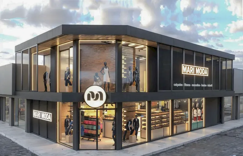 Projeto 3D da fachada de esquina da loja de roupas 'Mari Moda', com vitrines de vidro nos dois andares, esquadrias escuras e iluminação que destaca os manequins.
