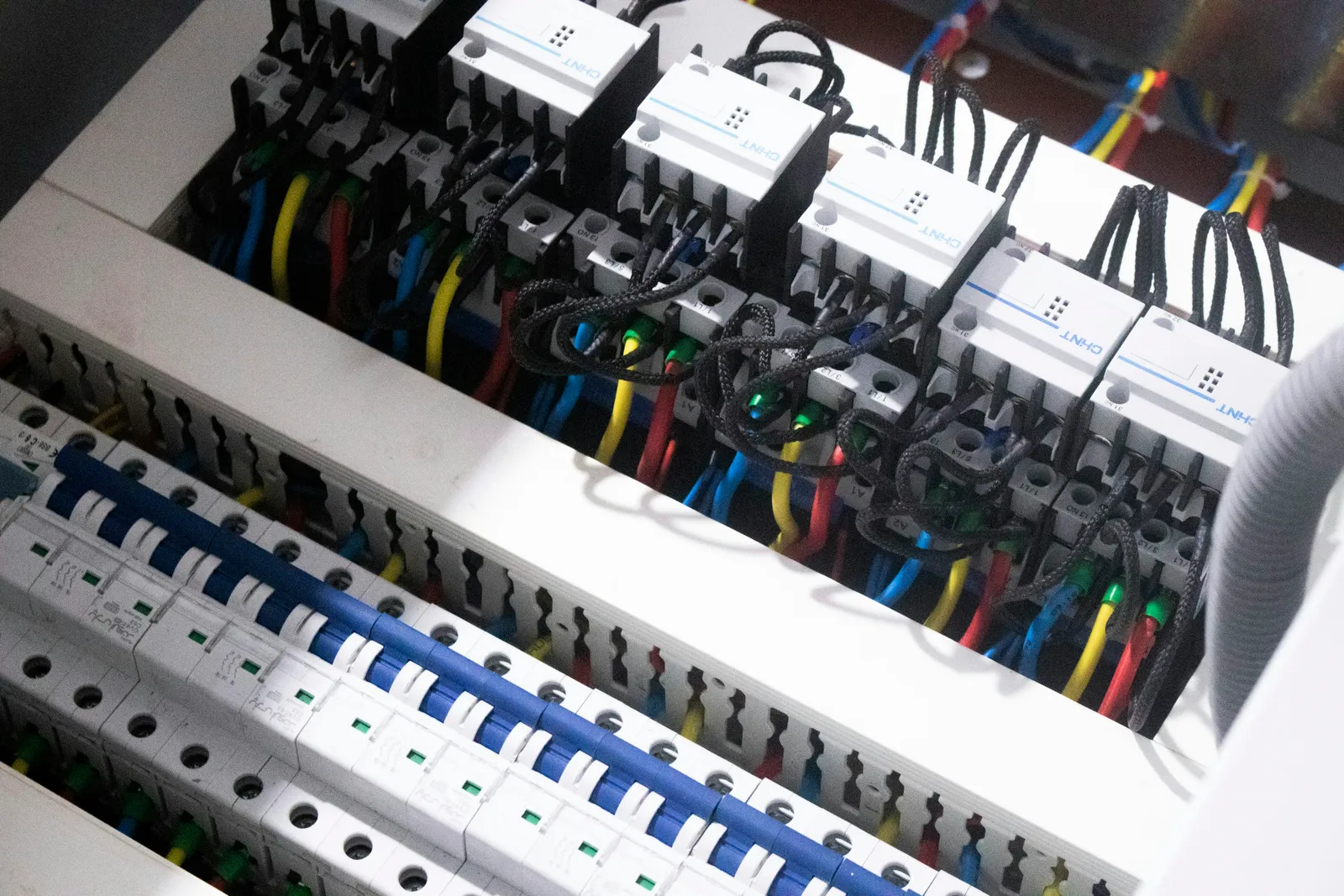 Quadro de distribuição elétrica com disjuntores e fiação organizada em instalação predial