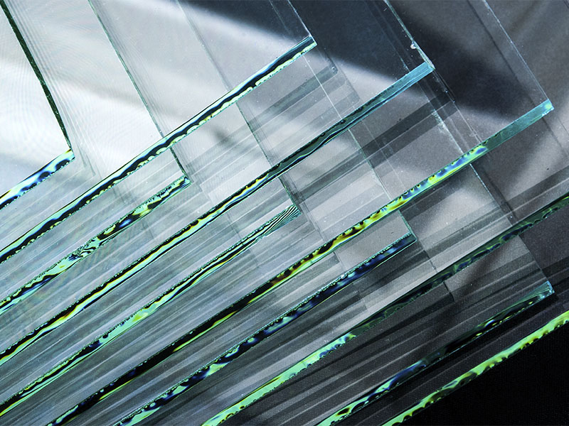 Aplicações Essenciais do Vidro Laminado em sua Casa e Empresa Close-up de chapas de vidro laminado empilhadas, destacando a película de PVB visível entre as lminas de vidro, que garante a segurança do material