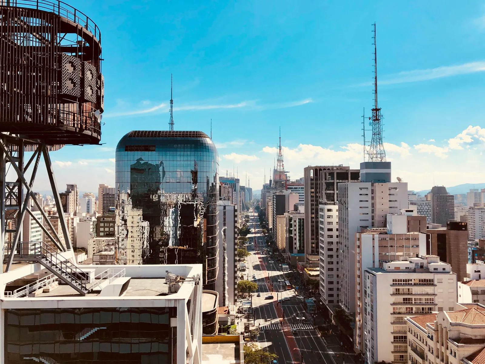 Caixa d'água comum instalada no telhado de um edifício Reservatório de água industrial instalado sobre o telhado de um prédio, com o horizonte de uma cidade ao fundo