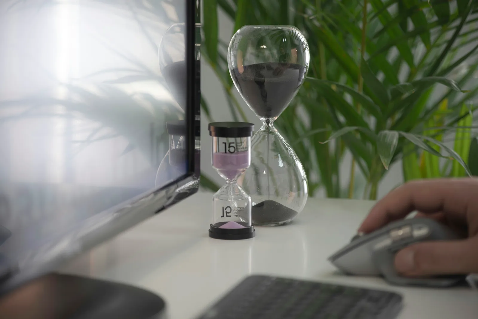 Ampulheta ao lado de temporizador em mesa de escritório, representando o tempo de resposta de um SLA de manutenção predial