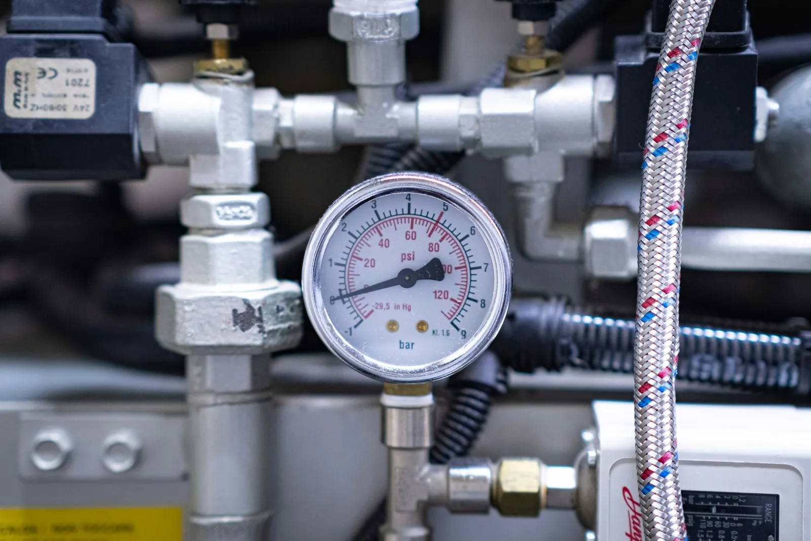 Leitura do manômetro durante o teste de estanqueidade hidráulica predial Técnico lê a pressão em um manômetro conectado à tubulação durante o teste de estanqueidade