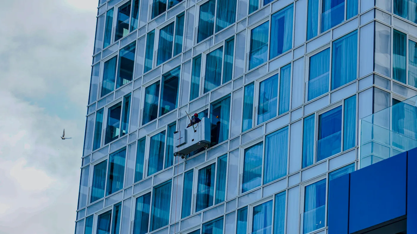 Troca de vidro de fachada em altura com seguranca Instalacao de painel de vidro em fachada de edificio por equipe especializada em trabalho em altura