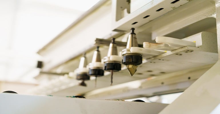 Detalhe do processo de usinagem do ACM, mostrando as ferramentas que garantem o acabamento perfeito e a customização dos painéis para projetos arquitetônicos.