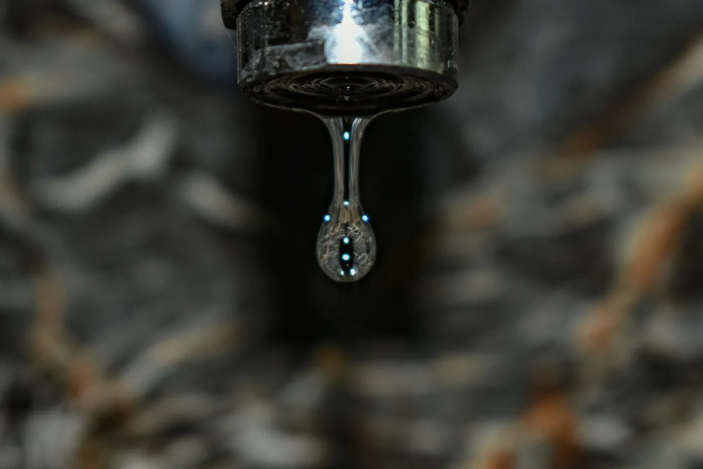 Vazamento de água: gotejamento contínuo indica problema na rede Gota de água pingando de torneira, sinal comum de vazamento em rede hidráulica