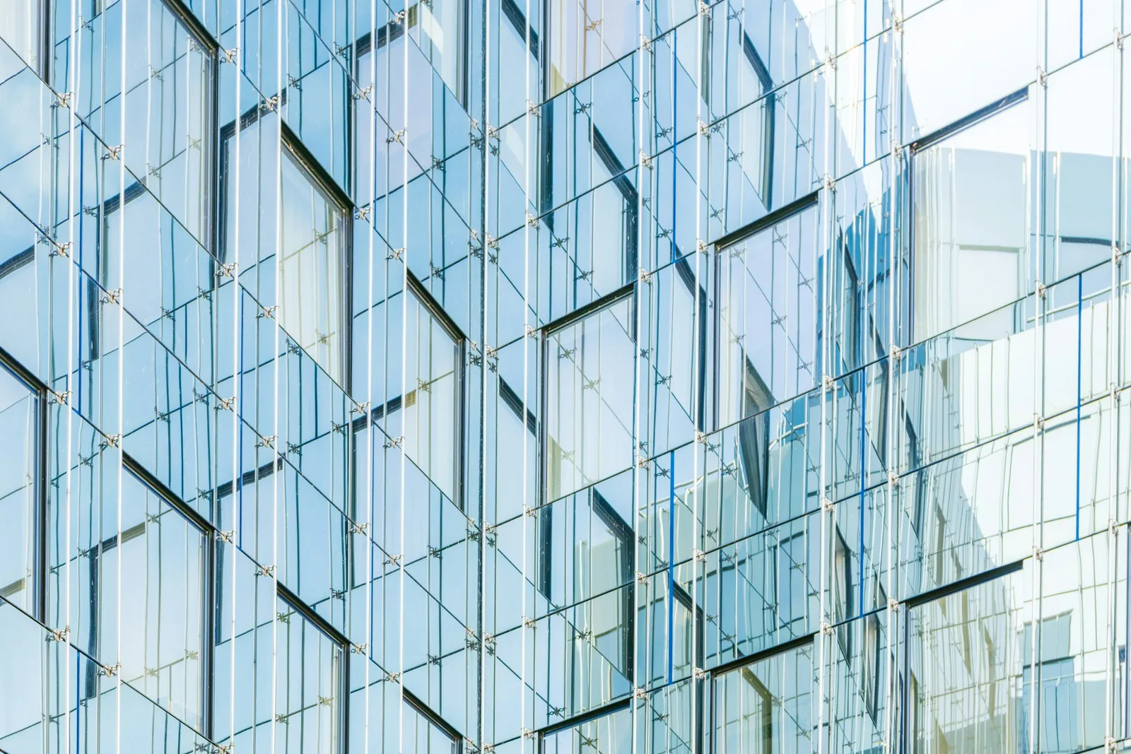 Fachada de vidro de edificio moderno refletindo a luz do sol; o vidro de controle solar melhora o conforto termico