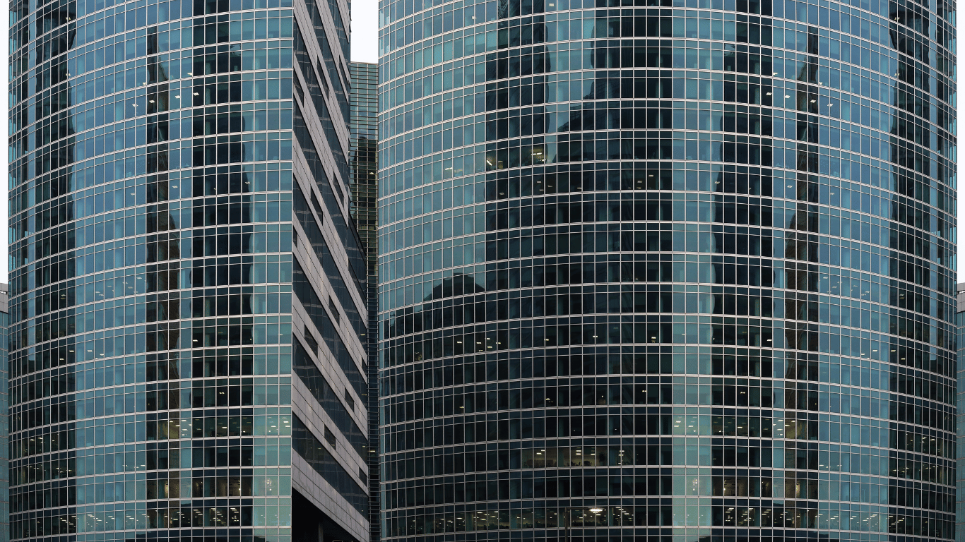 Fachada curvada de vidro com sistema Structural Glazing em edifício comercial moderno.