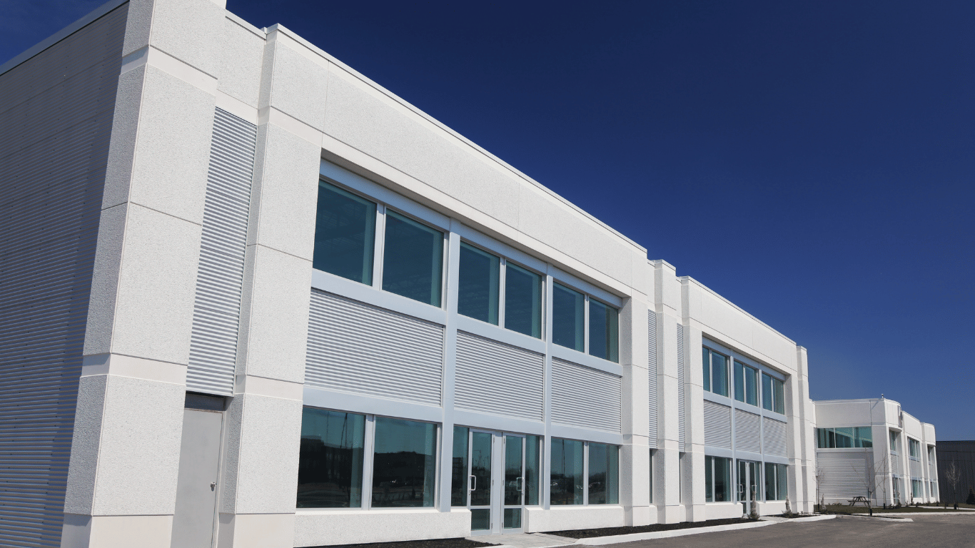 Prédio comercial moderno com grandes janelas de vidro e fachada estruturada.